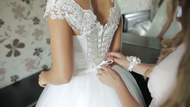 Fiocco di legatura damigella d'onore su abito da sposa. La sposa si prepara per la cerimonia nuziale. Abito da sposa primo piano — Video Stock