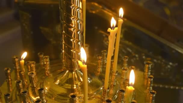 Brandende kaarsen van de wax voor het altaar in de kerk. Selectieve aandacht. — Stockvideo