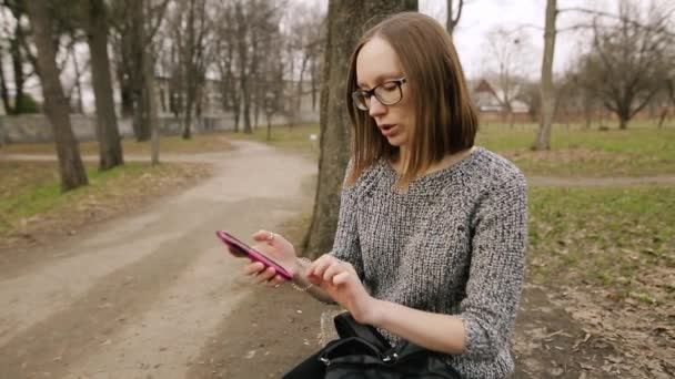 Muchacha atractiva explica a un amigo o padres cómo usar un teléfono inteligente . — Vídeos de Stock