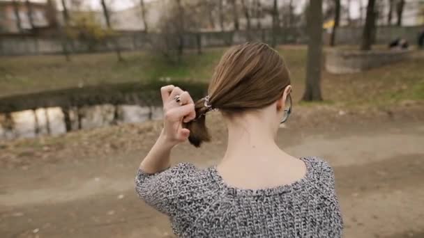Mulher remove scrunchie de sua cabeça, visão traseira . — Vídeo de Stock