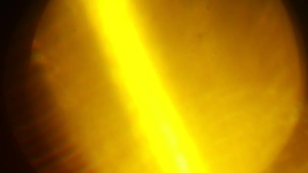 Warm yellow light pulses and glows. Beautiful light leak in warm hue on dark background. — Stock Video