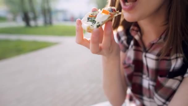 Detail einer Frau, die draußen auf der Straße leckere Pizza isst. — Stockvideo