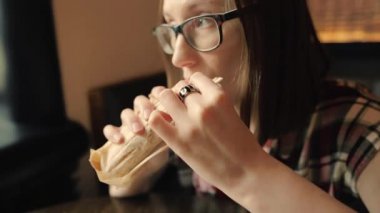 Aç kadın gözlük closeup lezzetli tavuk shawarma yiyor.