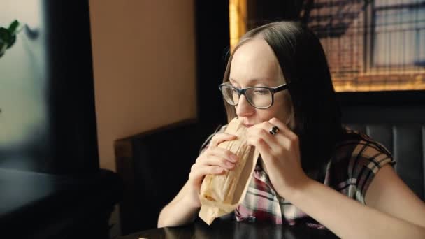 Hungrige Frau isst eine leckere Hühnershawarma oder einen Döner. — Stockvideo