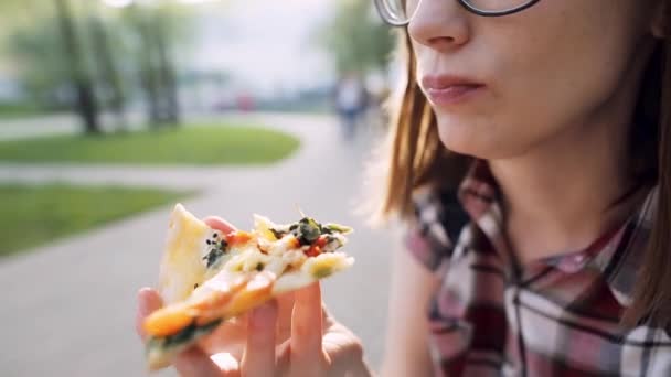 Primer plano de una mano femenina con una rebanada de pizza vegetariana. Profundidad superficial del campo . — Vídeos de Stock