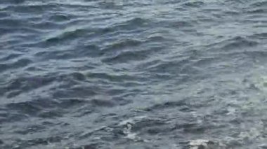 Dalgalar iskeleye çarpar ve en küçük sıçramalarda uçar. Sörf, Karadeniz, yavaş çekim..