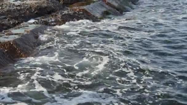 Sahildeki kayalarda deniz dalgaları kopuyor, yaz zamanı.. — Stok video