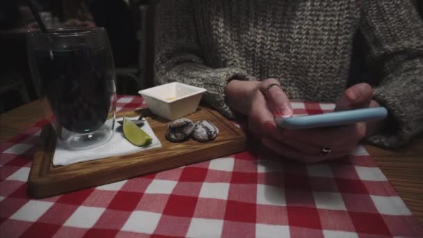 Μαθήτρια δακτυλογραφεί sms στο smartphone, συνομιλεί, σερφάρει στο διαδίκτυο, διαβάζει μενού cafe, επικοινωνεί με φίλους σε ένα κοινωνικό δίκτυο. — Αρχείο Βίντεο