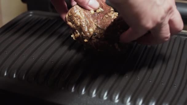 Samičí ruce rozprostírají maso marinované bylinkami a kořením na elektrickém grilu. — Stock video