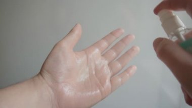 Adamın biri eline alkol el dezenfektanı sürüyor. Kişisel hijyen kavramı. 