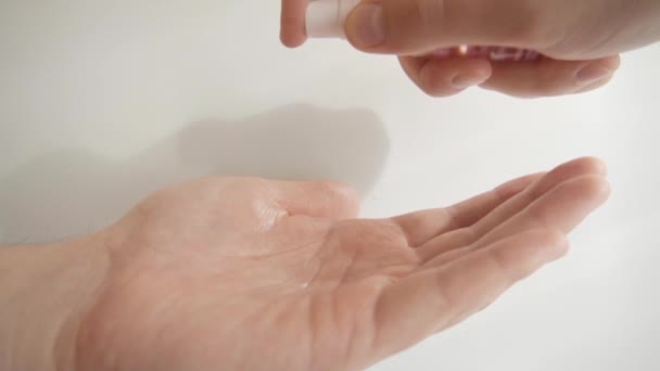 Man die antibacteriële alcohol reiniger op de handen aanbrengt. Langzame beweging. — Stockvideo
