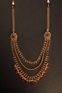 Orijinal Geleneksel Hint Mücevherleri. Karanlık Arkaplanda Kolye. Düğünde Boyun 'da, Festivallerde ve Diğer Olaylarda Giyin. Web Sitesi, Yazdırma ve Mobil Uygulama için çok kullanışlı bir resim.