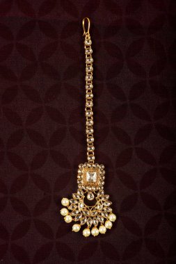 Orijinal Geleneksel Hint Mücevherleri Tika Karanlık Arkaplanda. Düğünde, festivallerde ve diğer etkinliklerde kafanızı takın. Web Sitesi, Yazdırma ve Mobil Uygulama için çok kullanışlı bir resim.