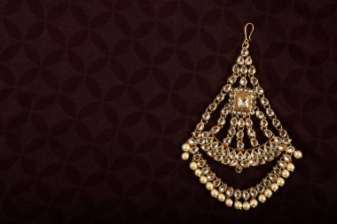 Orijinal Geleneksel Hint Mücevherleri Tika Karanlık Arkaplanda. Düğünde, festivallerde ve diğer etkinliklerde kafanızı takın. Web Sitesi, Yazdırma ve Mobil Uygulama için çok kullanışlı bir resim.