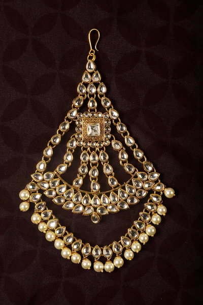 Authentiques bijoux indiens traditionnels Tika sur fond sombre. Portez-le à la tête lors de mariages, festivals et autres occasions. Image très utile pour le site Web, l'impression et l'application mobile . — Photo