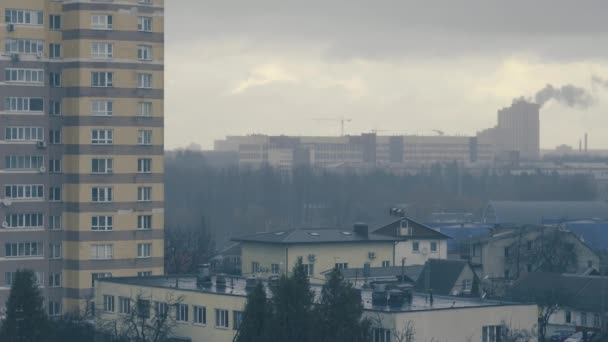 Czas ucieka w deszczowe, zachmurzone, mgliste dni. Szary, nieopisany widok na miasto Mińsk. Żuraw dymny i budowlany. — Wideo stockowe