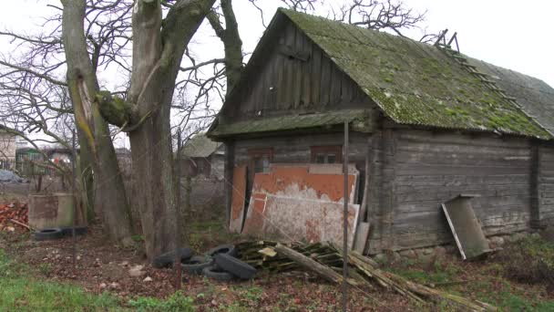 Opuszczony, zrujnowany stary drewniany dom. Okna i ściana z uszkodzonym starym dachem z farbą wietrzną. Zbliżenie. 4k. — Wideo stockowe