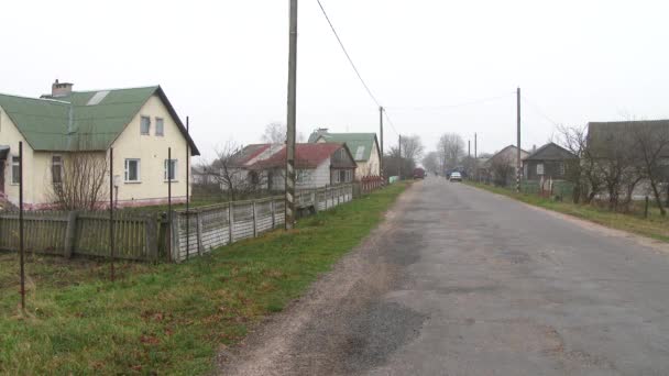 Köydeki yol. Küçük bir kasabada yıkılan bir asfalt yol. Kırsal yaşam kavramı. Köyde yalnız ve tozlu bir yol var. 4k — Stok video