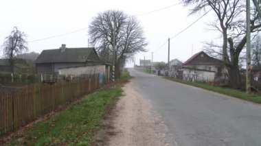 Köydeki yol. Küçük bir kasabada yıkılan bir asfalt yol. Kırsal yaşam kavramı. Köyde yalnız ve tozlu bir yol var. 4k