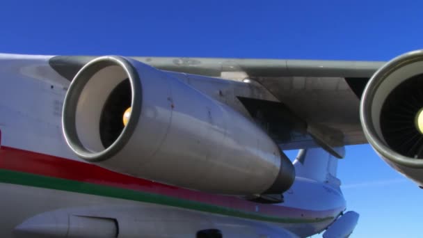 Motor a reacción de un avión de pasajeros que sigue en funcionamiento girando mientras el avión está estacionado en la puerta . — Vídeos de Stock