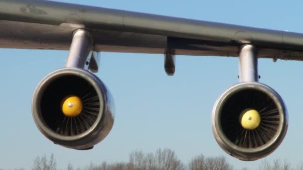Motor a reacción de un avión de pasajeros que sigue en funcionamiento girando mientras el avión está estacionado en la puerta . — Vídeo de stock