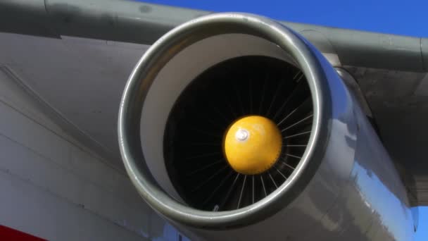 Jetmotor i ett flygplan som fortfarande är i funktion roterar medan planet står parkerat vid grinden. — Stockvideo