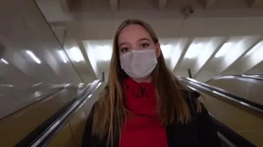 Tıbbi maske takmış genç bir sarışının portresi. Trafiğin en yoğun olduğu saatte metroda yürüyor. Hareket kısıtlaması. Olağanüstü hal. COVID-19 4K