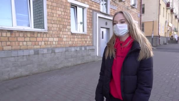 コロナウイルスの流行を防ぐために顔の保護を身に着けて街を歩く路上のウイルスマスクの女性19 食事のための検疫上の公共のスペースで歩く女性4K — ストック動画