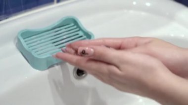 Kadın eli sabunu alır. Ellerini sabunla yıka sıcak suyla ovala parmaklarını sık sık yıka ya da dezenfektan jel kullan. Coronavirus salgını önleme. Deriyi temizliyorum. 4K yakın.