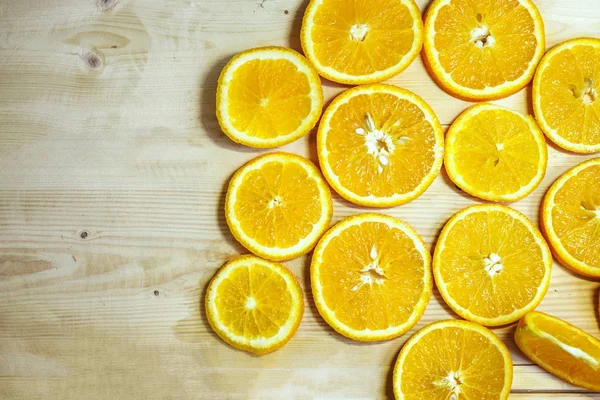 bright orange juicy oranges cut into circles lie on a wooden table