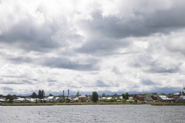 Kasvetli gökyüzü arka plan üzerinde yatay yeşil çayır ve Mavi Göl.
