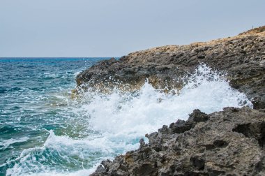 Malta Adası Comino kayalık sahil şeridi üzerinde çökmesini dalga.