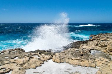 Azure pencere Gozo Adası, Malta eksik yakınındaki doğal tuz tava ile kayalık deniz kenarı sıçramasına dalga.