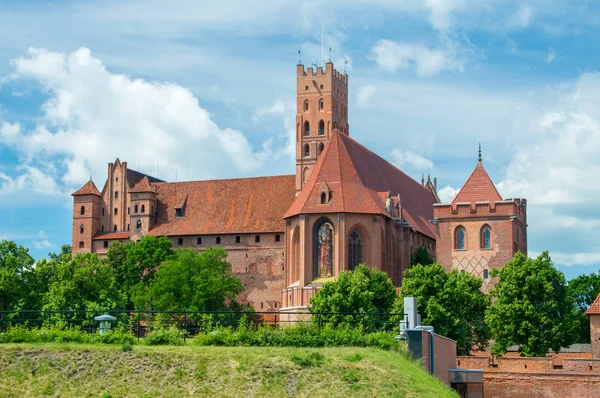 De vestingwerken van het kasteel van de Duitse orde in Malbork uit Oosten. Malbork kasteel is is het grootste kasteel in de wereld gemeten door landoppervlakte. — Stockfoto
