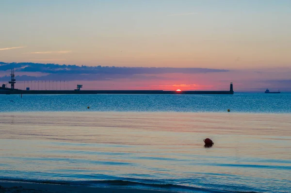 Salida del sol con faro en el mar Báltico en Gdynia . — Foto de Stock