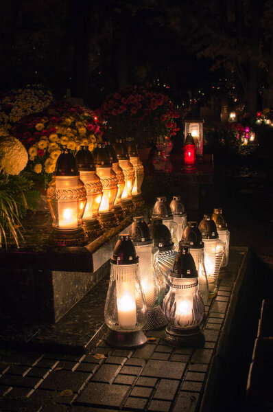 Graveyard candles on Polish cemetery during All Saints Day at night.