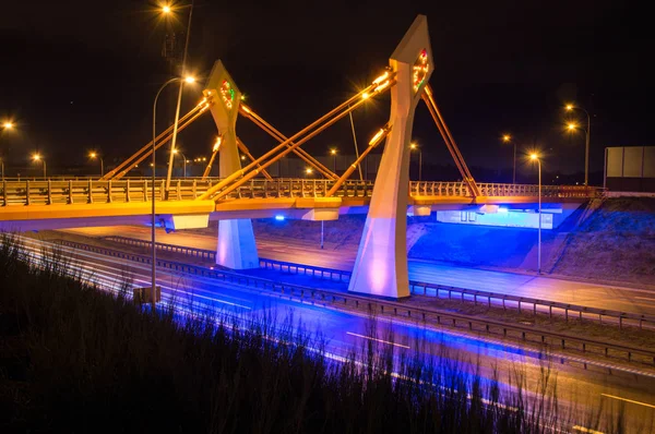 stock image Modern illuminated bridge over street at night in Gdansk in Poland.