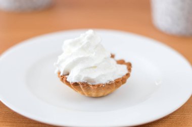 Beyaz plaka üzerinde krem şanti ile Polonya babeczka pasta.