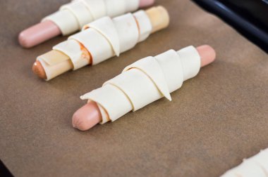 Peynir ve çiğ puf böreği ketçap ile sarmalanmış sosis.