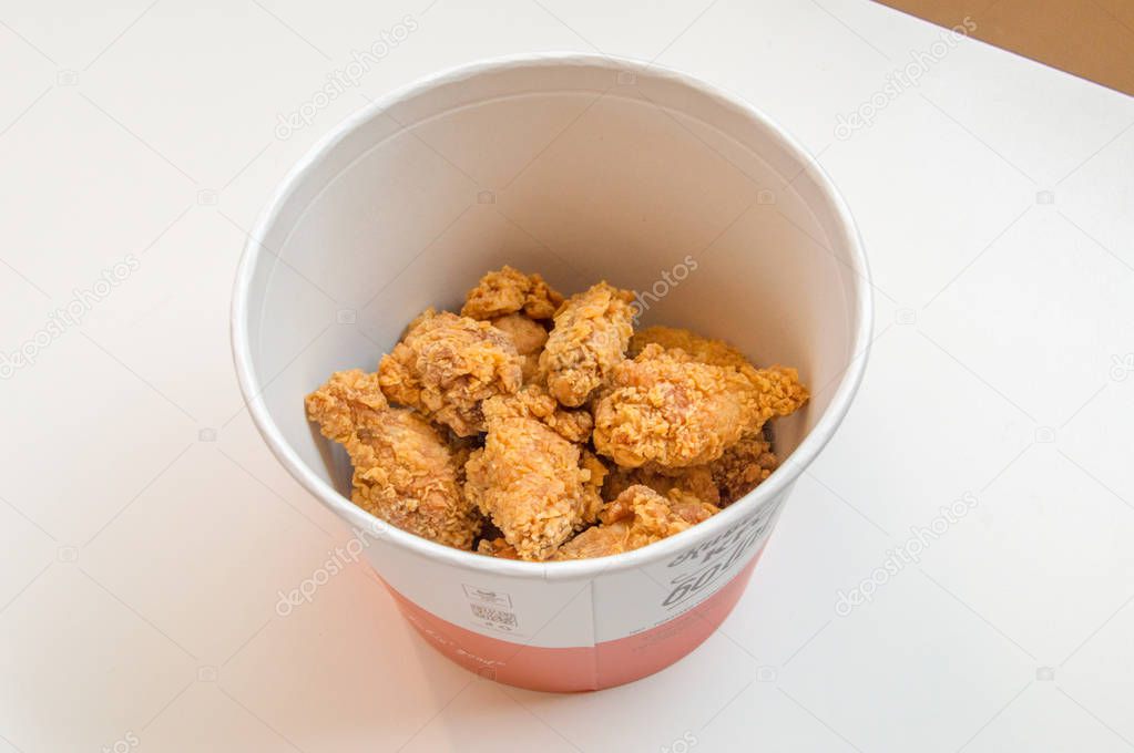 Gdansk, Poland - February 28, 2018: Bucket of fried chicken hot wings in KFC (Kentucky Fried Chicken) fast food.