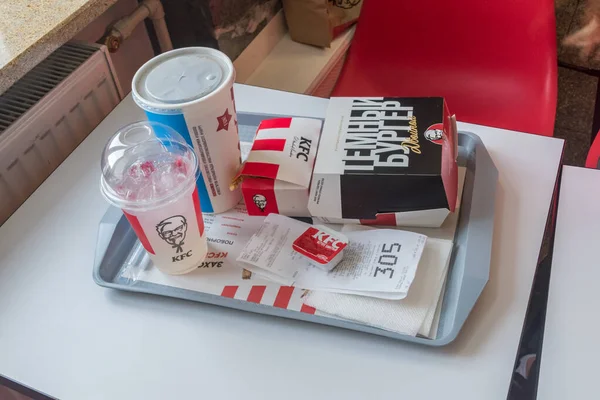 Comida y bebida en el restaurante KFC. Hamburguesa Doble Oscura, tiras de pollo, mojito y Pepsi . —  Fotos de Stock