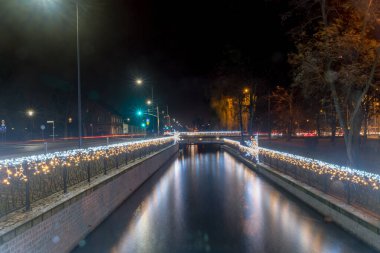 Geceleri Pruszcz Gdanski şehir merkezinde Noel süsleriyle Radunia Kanalı.