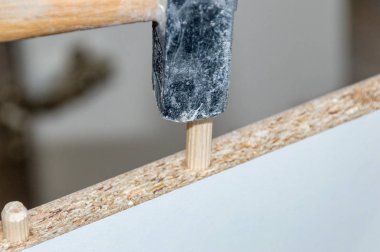 Mobilyalardaki deliğe tahta bir çivi çakmak..