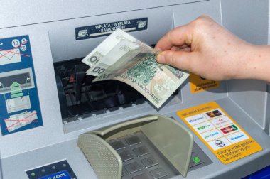 El, ATM 'den para alıyor. ATM 'de 100 Pln banknot.