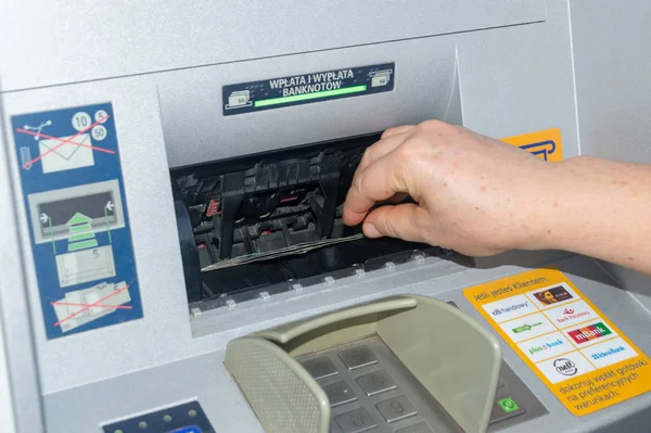 Retirar dinheiro da caixa multibanco. Notas de 100 PLN na máquina ATM . — Fotografia de Stock