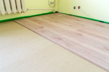 Odanın zemin panellerini çizgili panoların üzerine yerleştirmek.