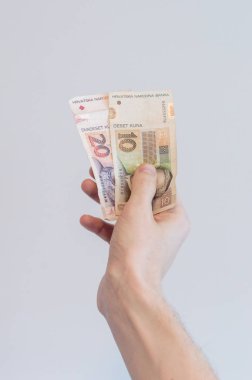 10 ve 20 Hırvat kuna banknotunu tutan adam (HRK).