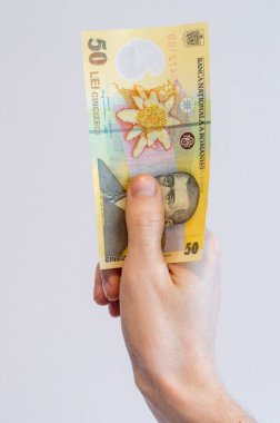 Man hand holding a 50 Romanian lei banknote. clipart