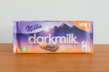 Pruszcz Gdanski, Poland - March 6, 2020: Milka darkmilk alpine milk chocolate bar with salted carmel and extra cocoa. clipart