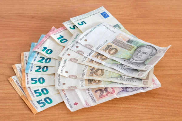 欧元和克罗地亚库纳钞票 Hrk 放在木制桌子上 — 图库照片